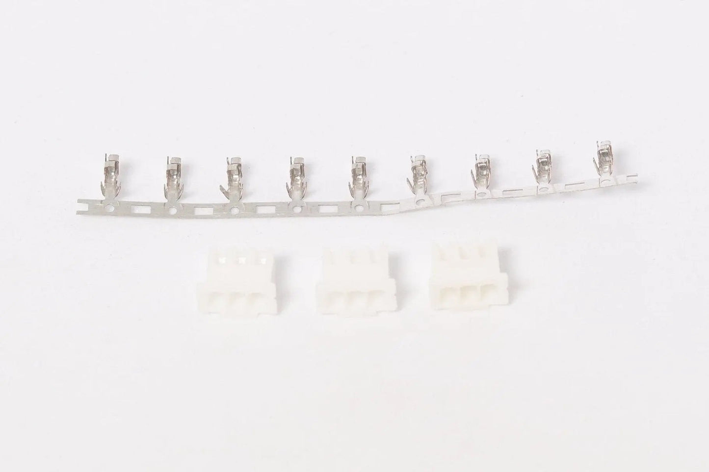 Bande de contacts JST translucides alignés en haut, avec trois boîtiers blancs 3 broches flous en bas