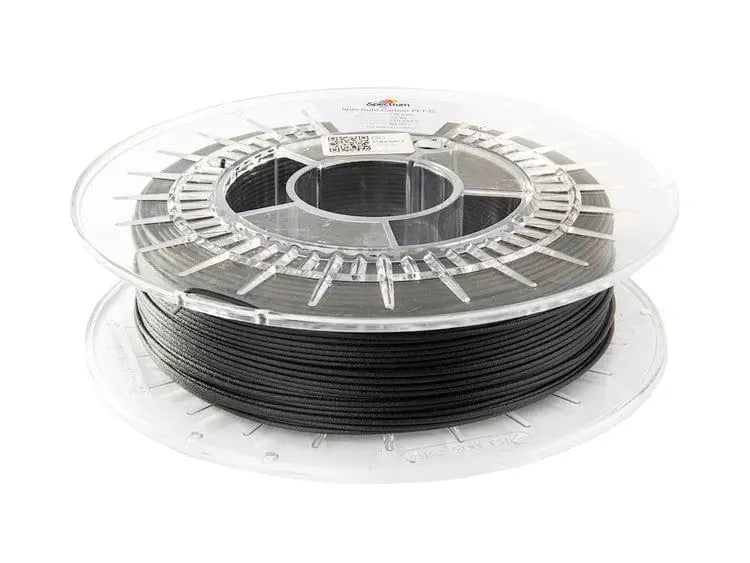 Bobine transparente de filament noir enroulée, vue de trois quarts sur fond blanc