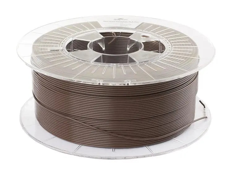 Bobine de filament marron chocolat sur une bobine transparente, vue de trois quarts sur fond blanc