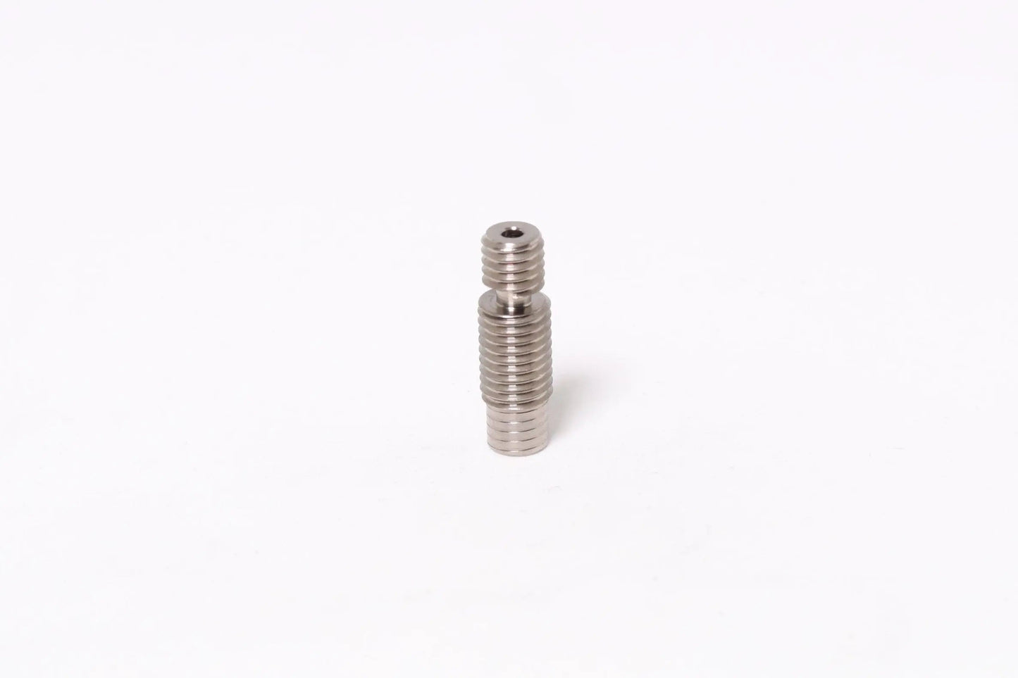 Petit tube fileté métallique vertical sur fond blanc, centré dans le cadre