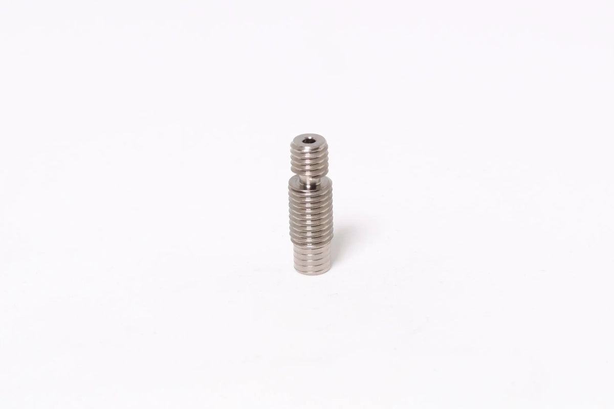 Petit tube métallique fileté vertical sur fond blanc, centré dans le cadre