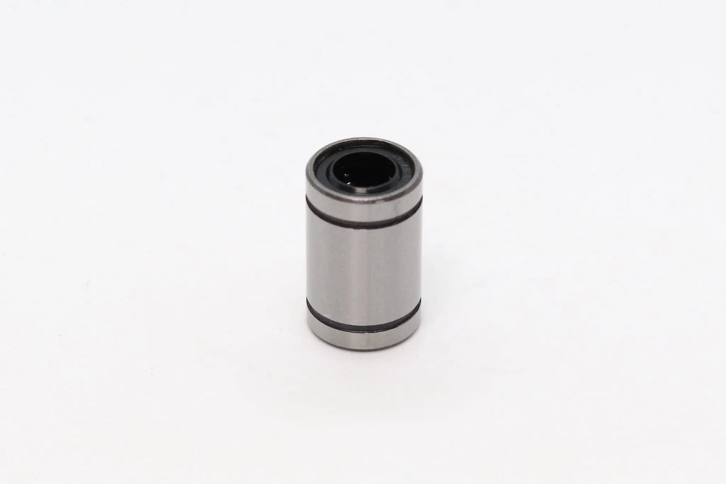 Petit roulement linéaire cylindrique métallique gris, isolé sur fond blanc