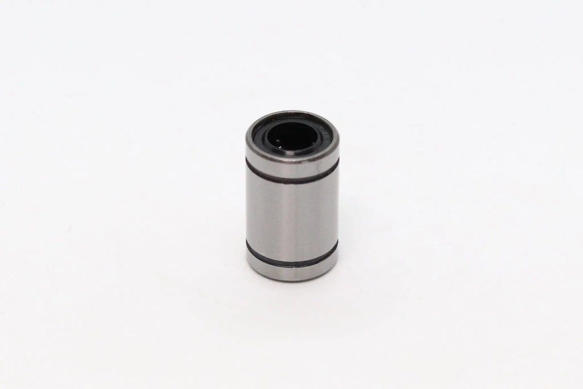 Palier linéaire cylindrique métallique gris posé seul sur fond blanc, vu de face