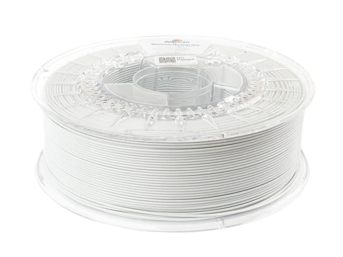 Bobine de filament gris clair enroulée sur une bobine transparente, vue de trois quarts