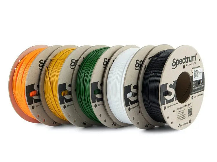 Cinq bobines de filament Spectrum alignées, en orange, jaune, vert, blanc et noir