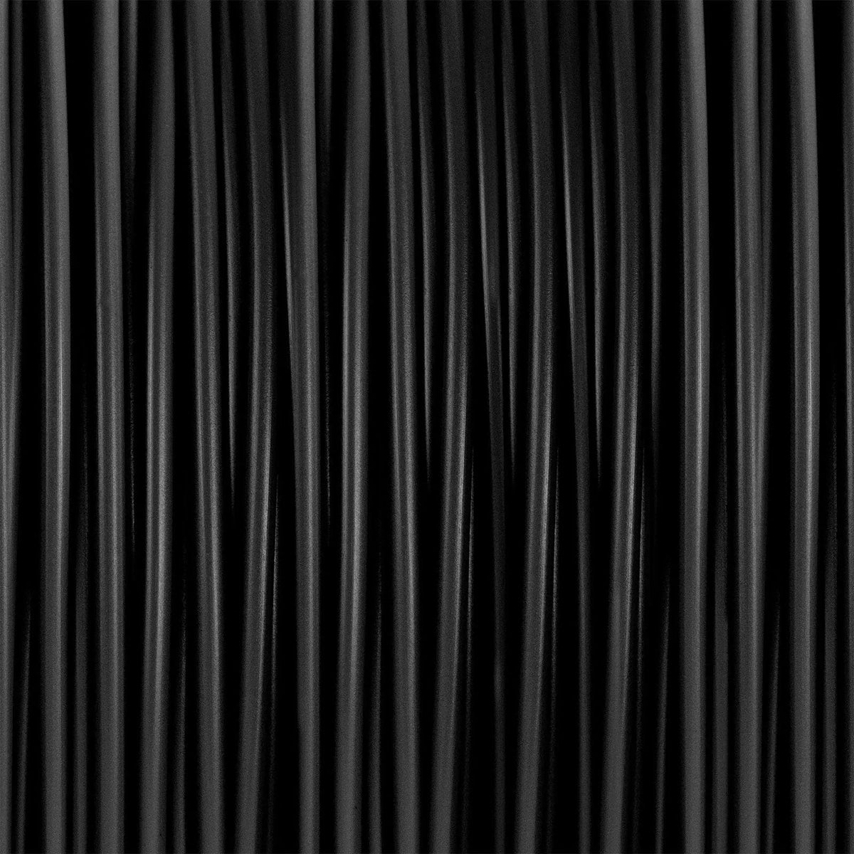 Gros plan de filaments noirs ondulés sur fond noir, sans emballage visible