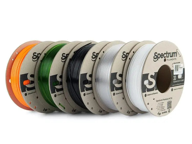 Cinq bobines de filament Spectrum alignées en éventail, avec des couleurs orange, vert, noir et blanc