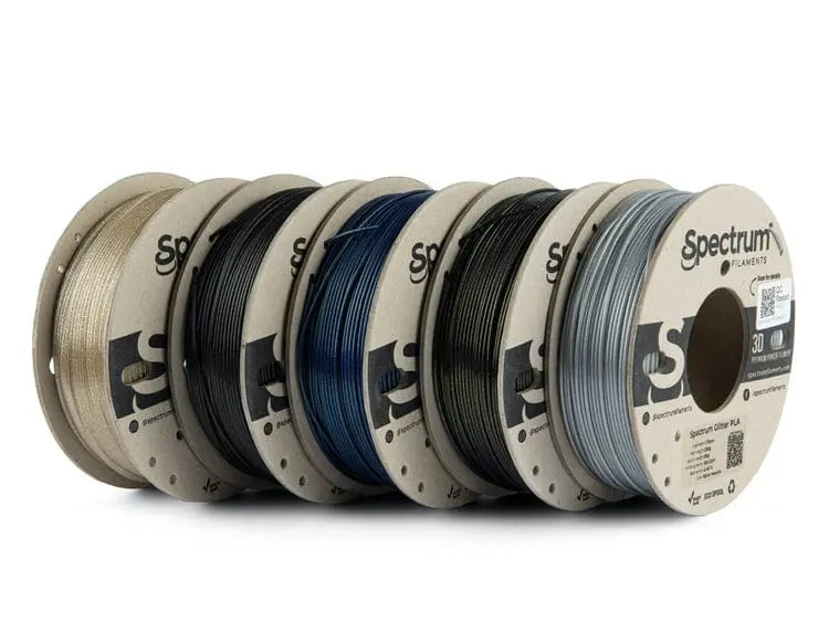 Cinq bobines de filament Spectrum alignées de trois-quarts, avec des couleurs beige, noir, bleu, noir et gris