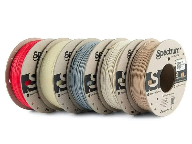 Cinq bobines de filament Spectrum alignées, aux couleurs rouge, crème, bleu, beige et sable, vues de face