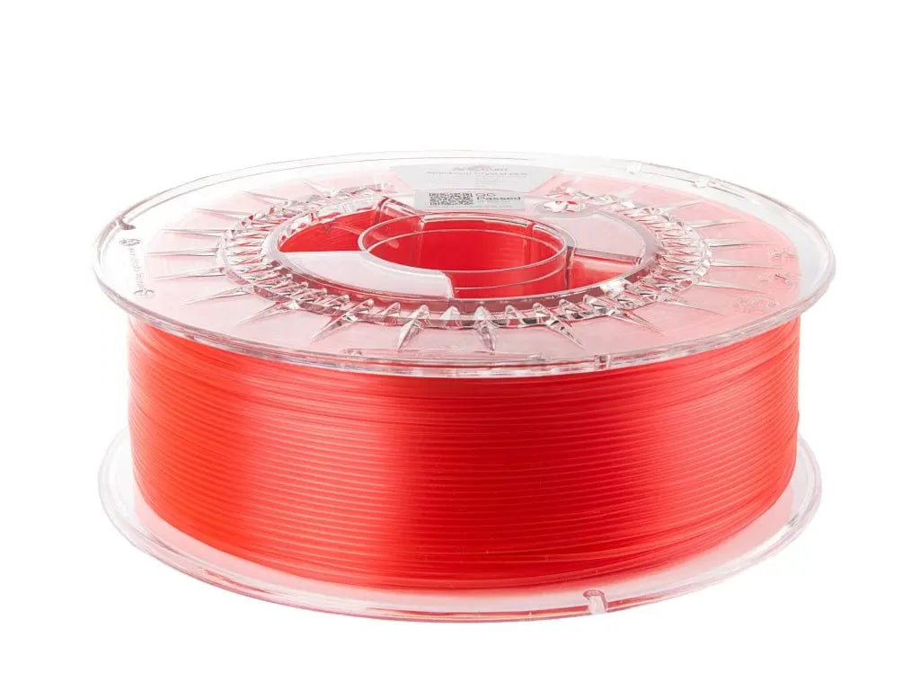 Bobine de filament rouge translucide sur dévidoir transparent, vue de trois quarts sur fond blanc