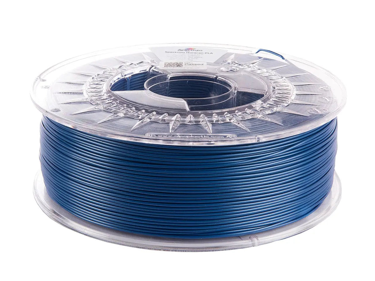 Bobine de filament bleu royal avec coque transparente, vue de côté sur fond blanc