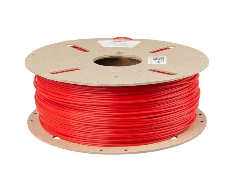 Bobine de filament rouge vif sur un support en carton, vue de trois quarts sur fond blanc