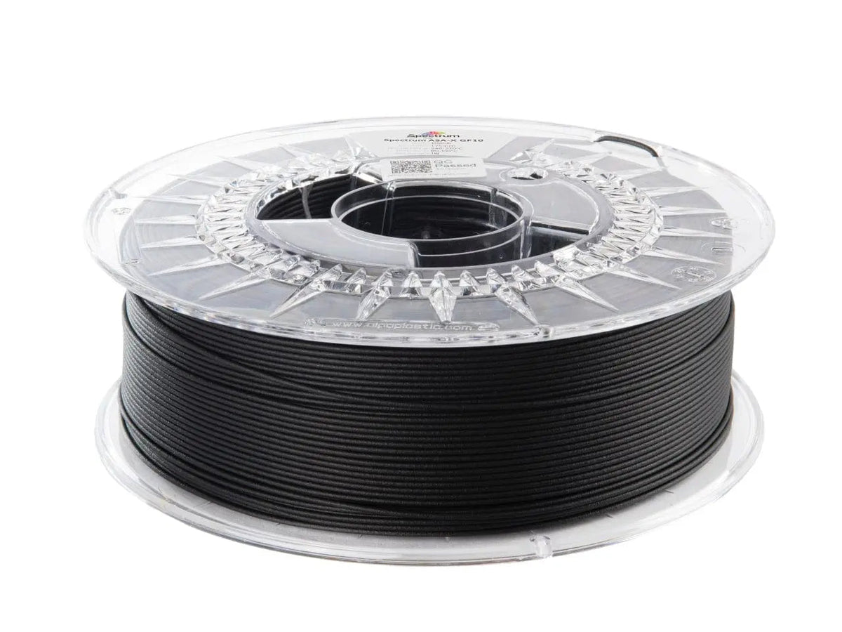 Bobine de filament noir sur une bobine transparente, vue de dessus sur fond blanc