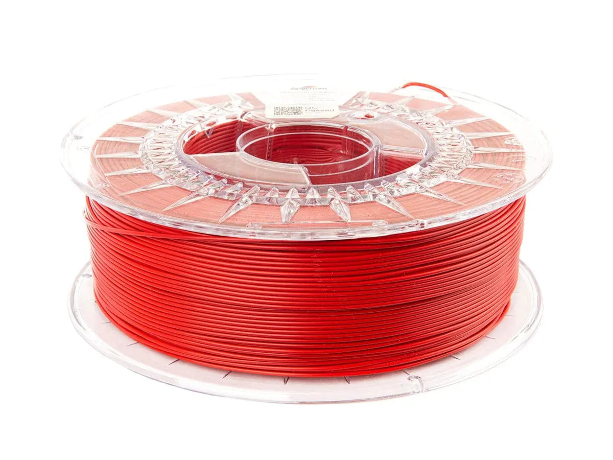 Bobine de filament rouge vif enroulée sur une bobine transparente, vue de trois quarts sur fond blanc