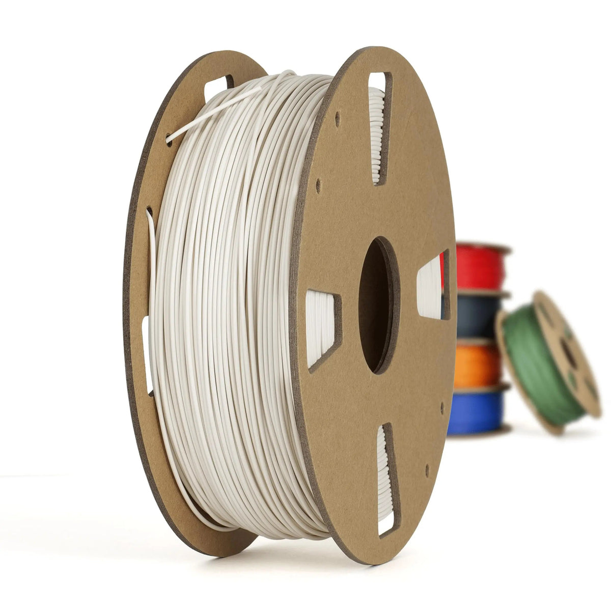 Bobine de filament blanc sur grand support en carton, avec plusieurs bobines colorées floues en arrière-plan