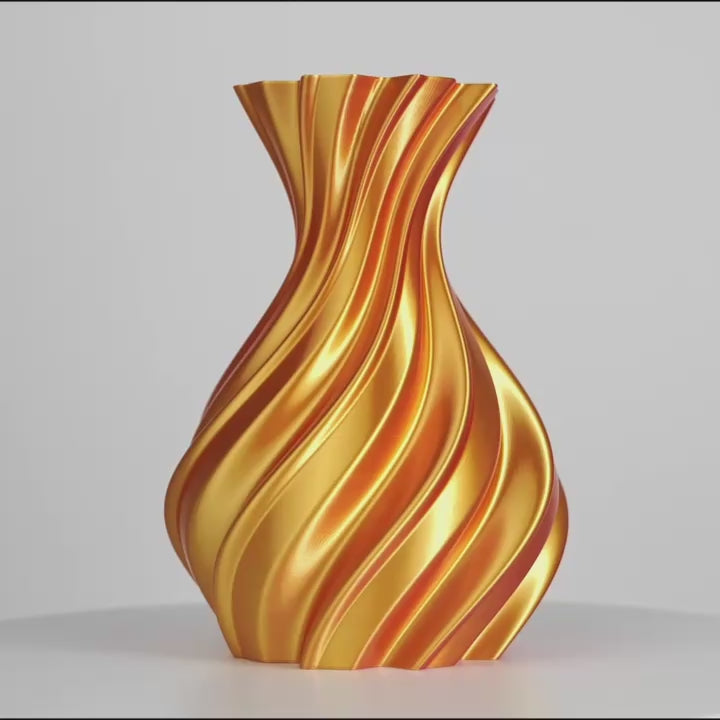 Objet décoratif en forme de vase torsadé rouge et or sur fond gris