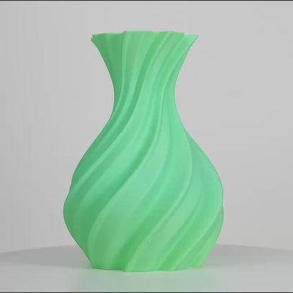 Vase vert menthe imprimé en 3D, posé sur fond gris, avec surface torsadée