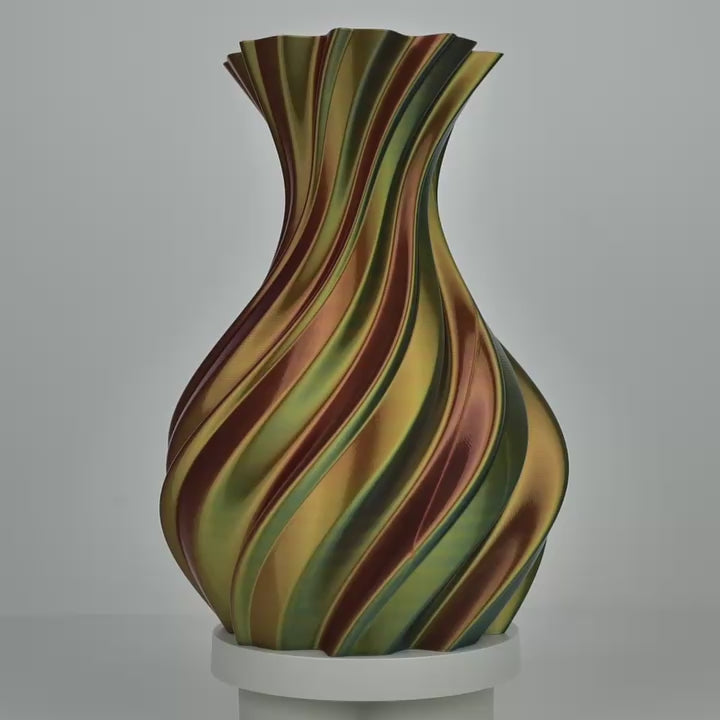Vase imprimé en 3D torsadé aux bandes rouge, jaune et bleu sur socle blanc