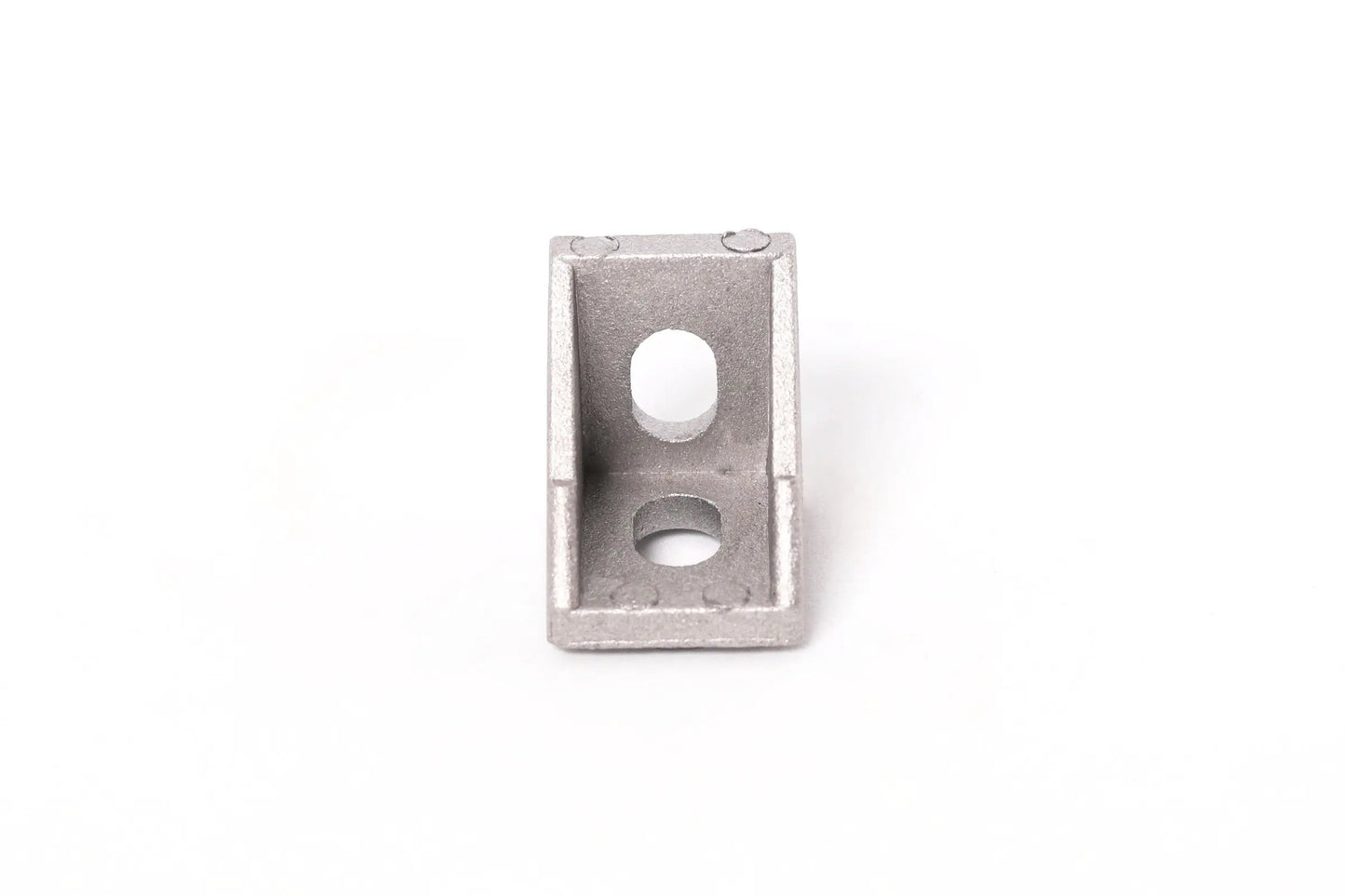 Vue de face d’une équerre d’angle en aluminium gris, avec deux trous ronds, sur fond blanc