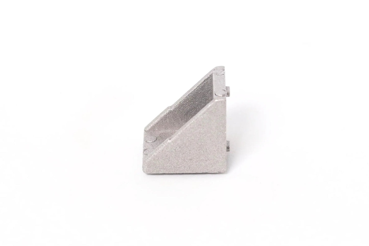 Vue de côté d’une équerre d’angle en aluminium gris, posée seule sur fond blanc