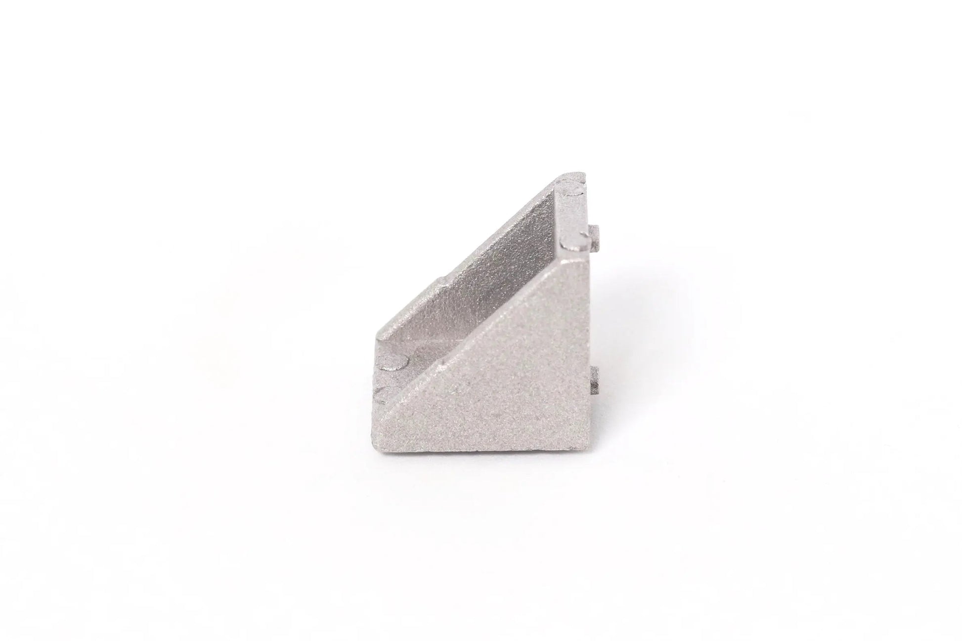 Vue de côté d’une équerre d’angle en aluminium gris, posée seule sur fond blanc