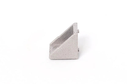 Vue de côté d’une équerre d’angle en aluminium gris, posée seule sur fond blanc
