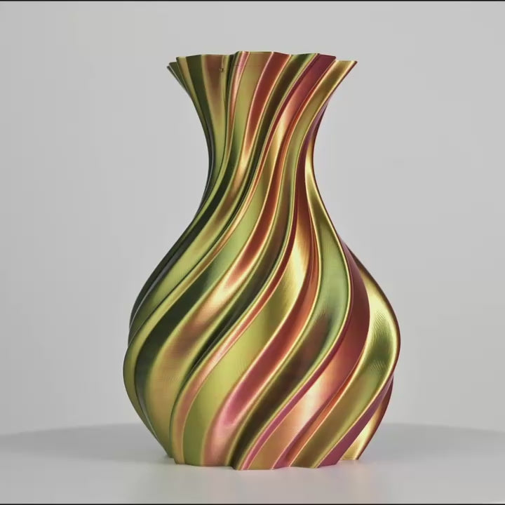 Vase ondulé imprimé en 3D aux bandes rouge, vert et or sur fond gris