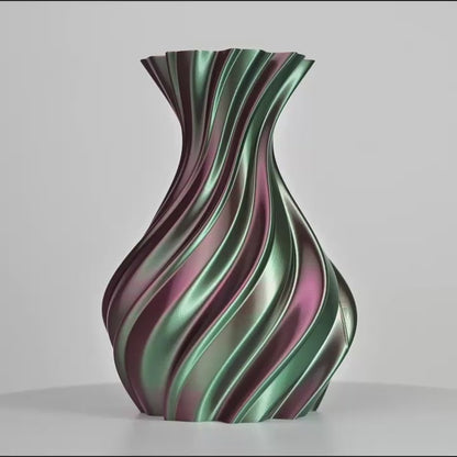 Vase torsadé imprimé en 3D avec bandes métalliques vert, rose et violet sur fond gris