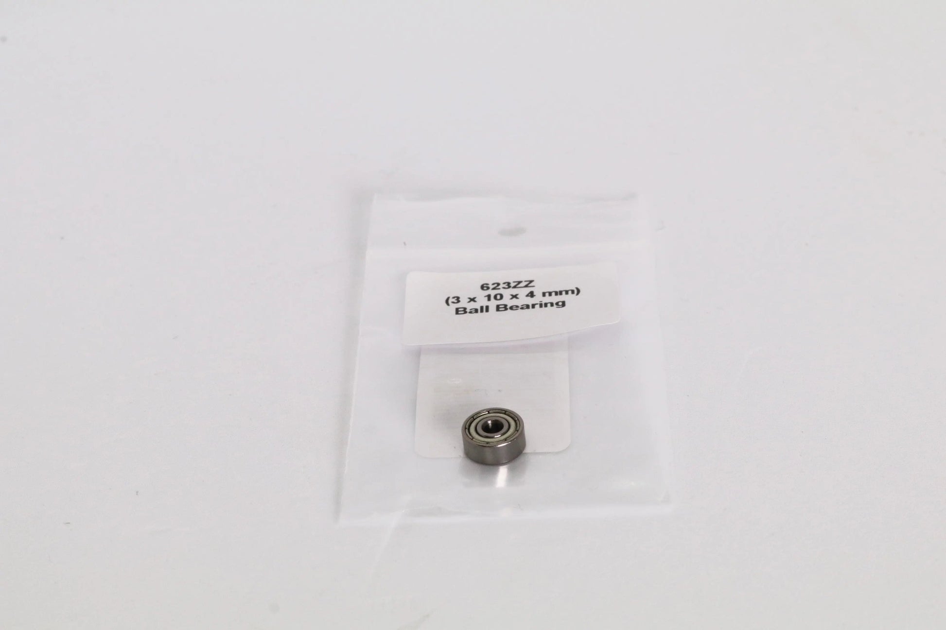 Un petit roulement métallique dans un sachet plastique transparent, étiquette « 623ZZ (3 x 10 x 4 mm) Ball Bearing » visible