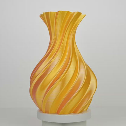 Objet décoratif imprimé en 3D en forme de vase torsadé jaune orangé sur fond gris