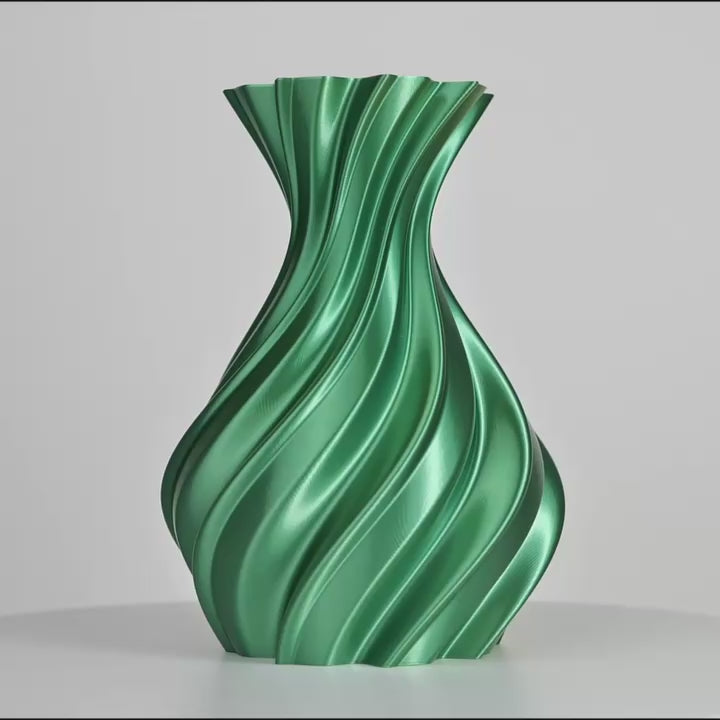 Vase vert métallique torsadé, centré sur fond gris clair