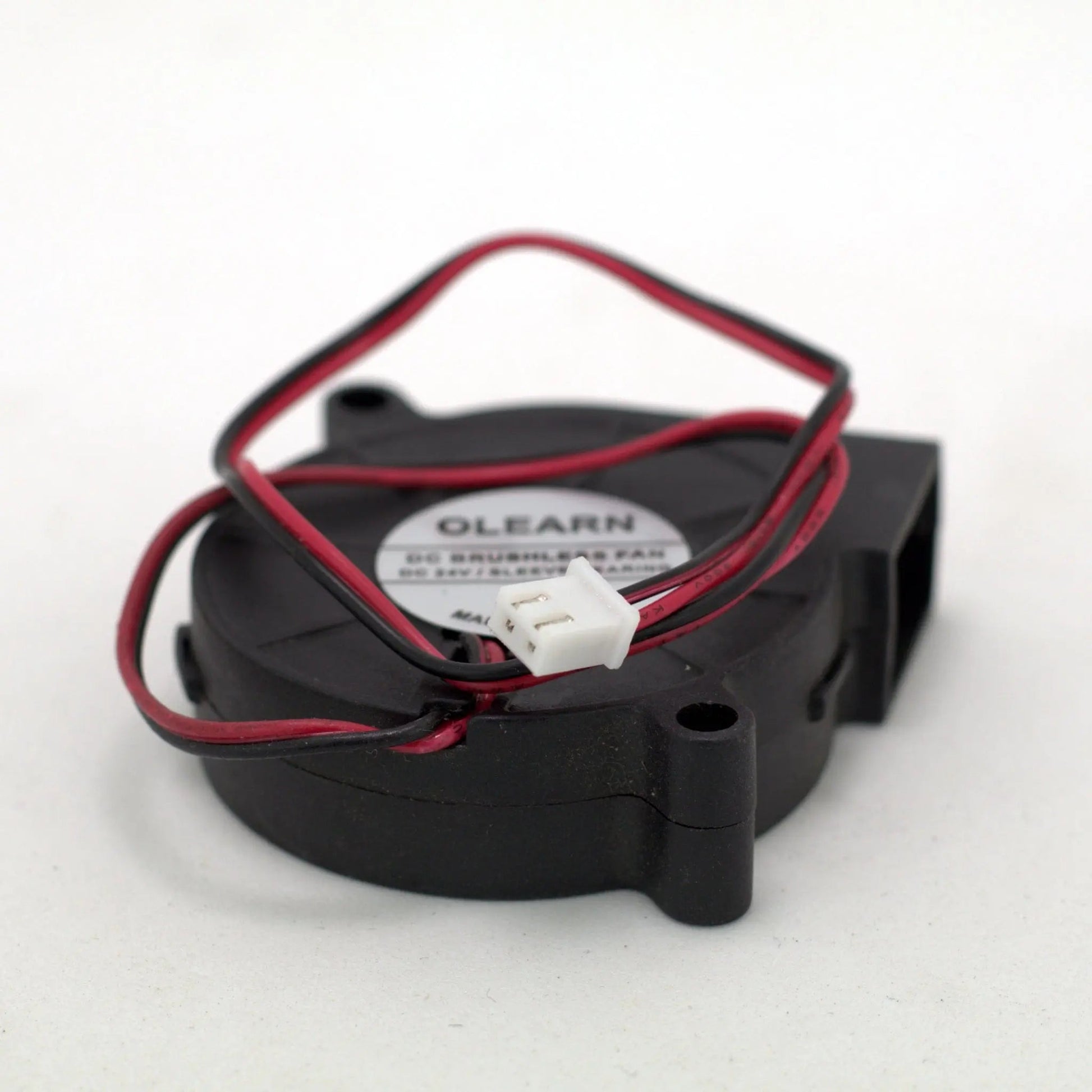 Vue rapprochée d’un ventilateur soufflant noir avec fils rouge et noir et connecteur blanc, sur fond blanc