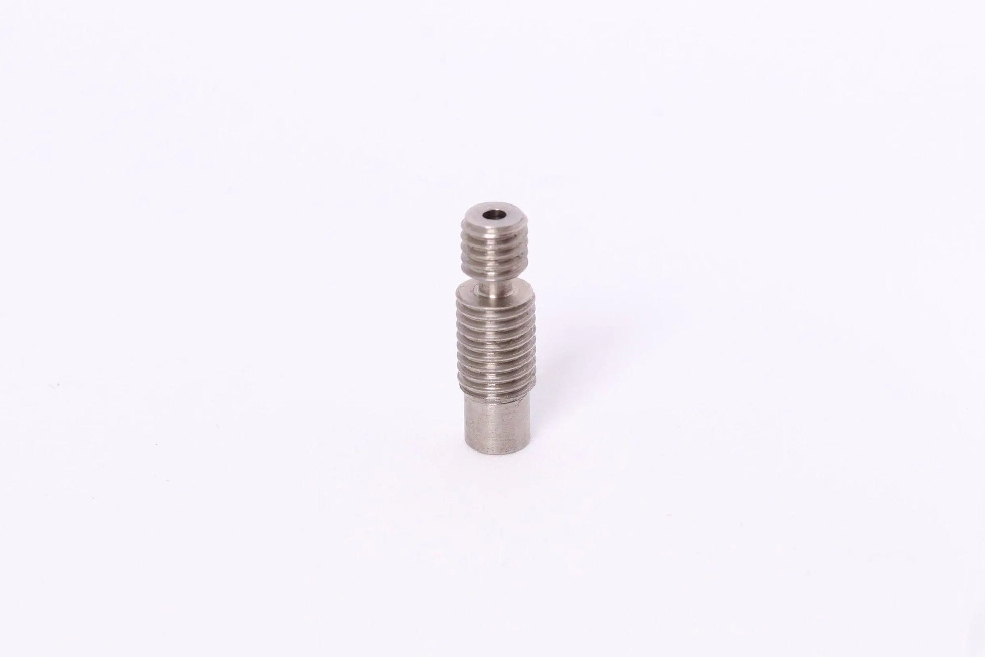 Petit composant métallique fileté verticalement sur fond blanc