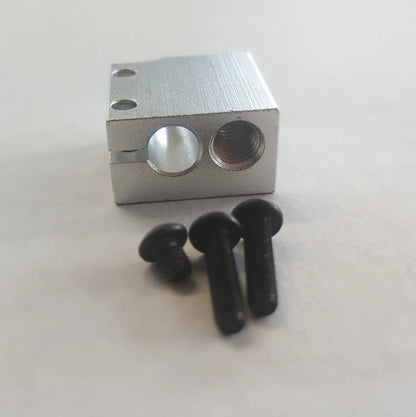 Bloc chauffant en aluminium argenté vu de face, avec trois vis noires au premier plan
