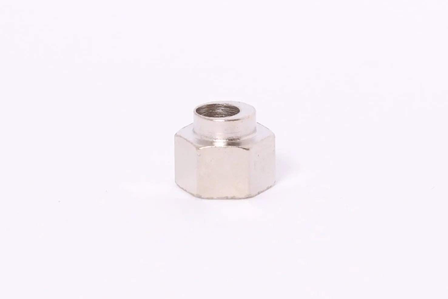 Pièce métallique hexagonale filetée, vue de face sur fond blanc