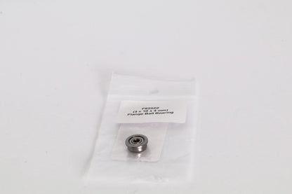 Petit roulement à billes à bride dans un sachet plastique transparent avec étiquette, posé sur fond blanc
