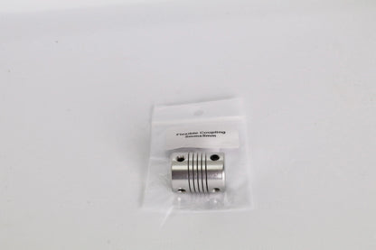 Petit coupleur flexible métallique argenté dans un sachet plastique transparent sur fond blanc