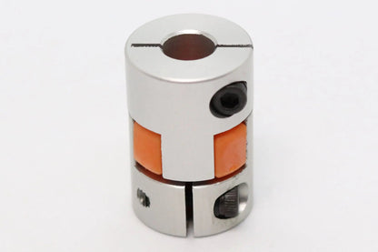 Accouplement d’arbre flexible métallique argenté avec insert orange, vu de face sur fond blanc