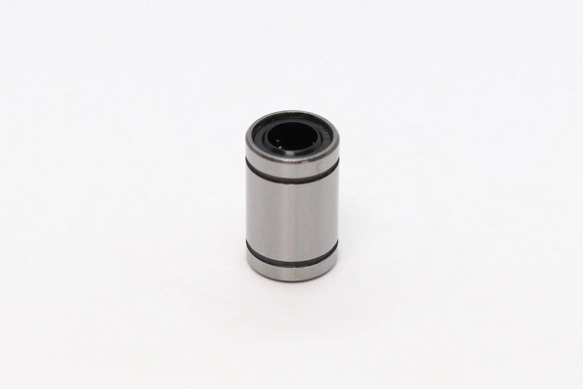 Petit roulement linéaire cylindrique métallique gris, isolé sur fond blanc