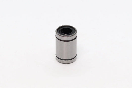 Petit roulement linéaire cylindrique métallique gris, isolé sur fond blanc