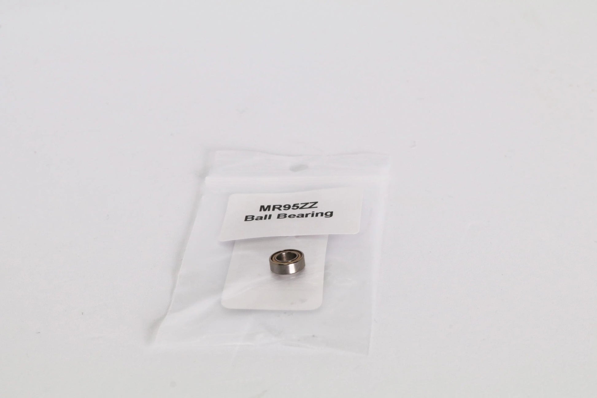 Petit roulement métallique dans un sachet plastique transparent avec étiquette « MR95ZZ Ball Bearing »