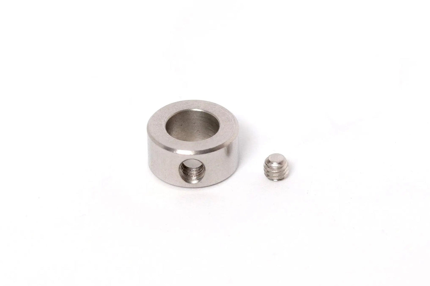 Collier métallique cylindrique percé, avec une petite vis à côté sur fond blanc