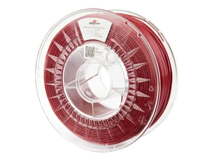 Bobine de filament rouge pailleté dans une spoule transparente, vue de face sur fond blanc