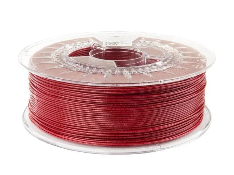 Bobine de filament PLA rouge scintillant dans une bobine transparente, vue de trois quarts sur fond blanc