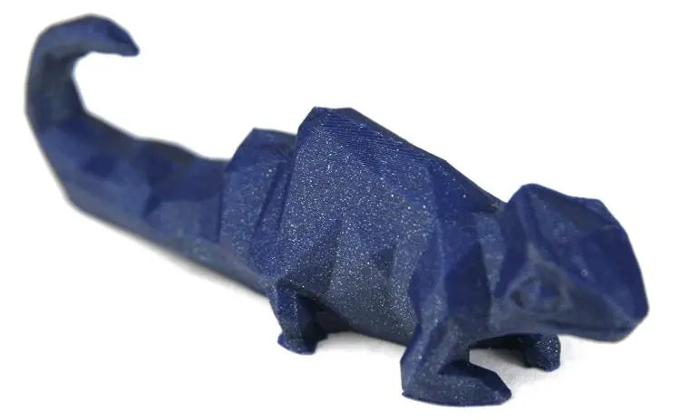 Gros plan d’un lézard imprimé en 3D bleu scintillant sur fond blanc