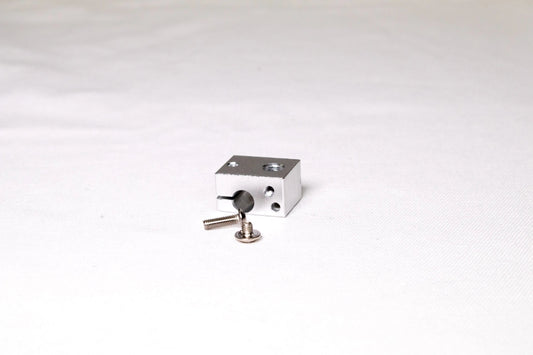 Petit bloc chauffant en aluminium argenté avec deux vis posés sur fond blanc