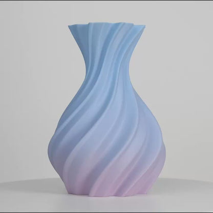Vase spiralé aux dégradés bleu et rose, centré sur fond gris